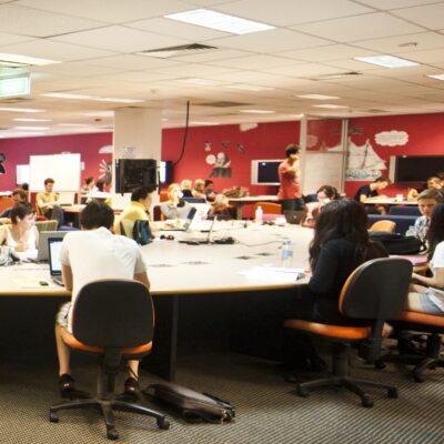 Students sitting around a table in a computer lab, Queensland University of Technology.