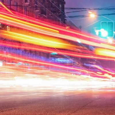 People standing by a busy road in Shanghai with timelapse image of traffic.