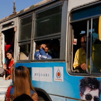 A street scene with people and a bus in Yangon.