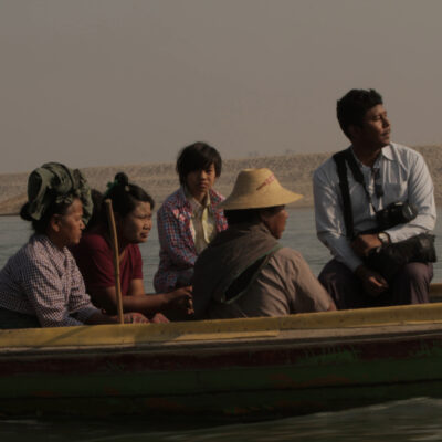 A boat carrying people, including Myint Zaw, on a river. Image used with permission from the Goldman Environmental Prize.