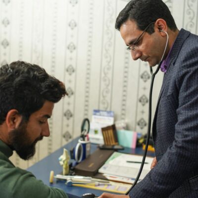 A patient consulting a doctor in a room.