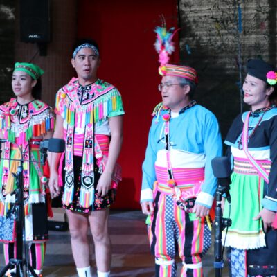 A group of people on stage in traditional dress - the Chu-Yin culture and Arts Troupe.