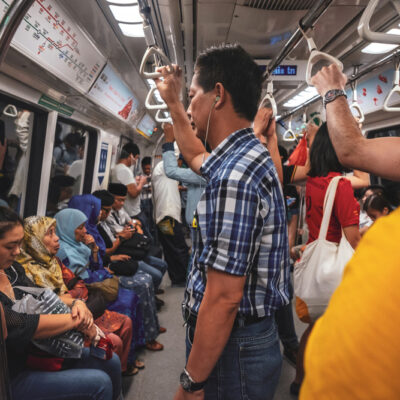 People in the interior of a crowded train in Singapore.
